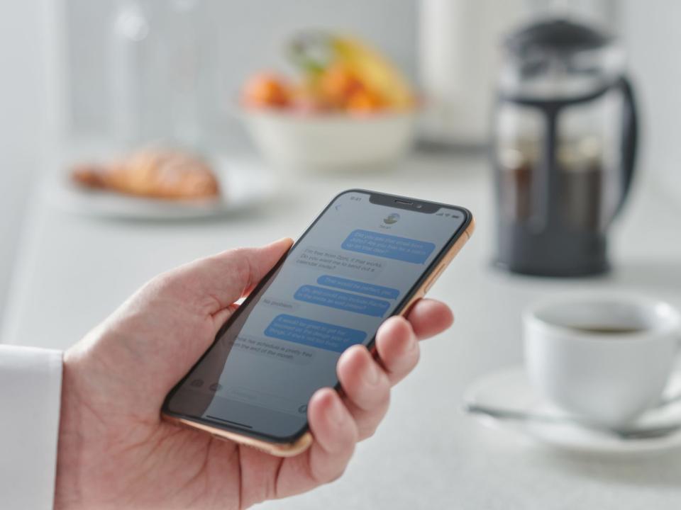 person looking at phone kitchen counter