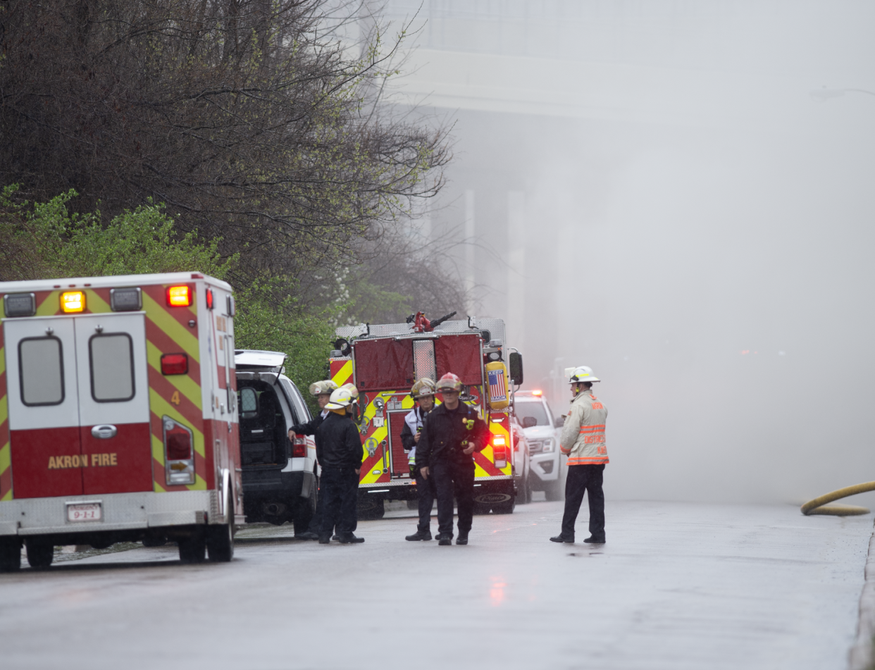 Smoke fills the area where first responders stand on Sweitzer Avenue as they work to extinguish a blaze at a vacant warehouse Thursday.