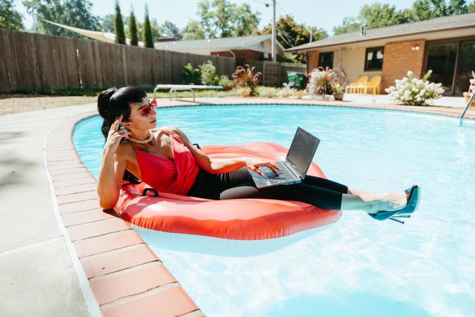 Jessie McCool laying on a pool float with her laptop.