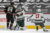 Minnesota Wild goaltender Cam Talbot reaches up to make a glove save as Arizona Coyotes center Lane Pederson (93) and Wild defenseman Carson Soucy (21) look on during the second period of an NHL hockey game Wednesday, April 21, 2021, in Glendale, Ariz. (AP Photo/Ross D. Franklin)