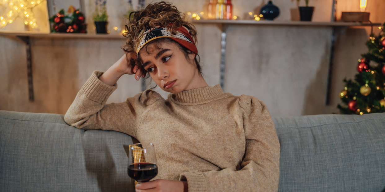 woman looking sad holding wine