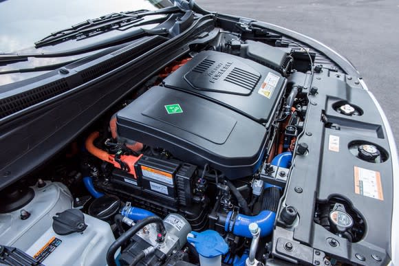 A view under the hood of a Hyundai Tucson Fuel Cell SUV. The fuel cell "stack" is visible under a black cover.