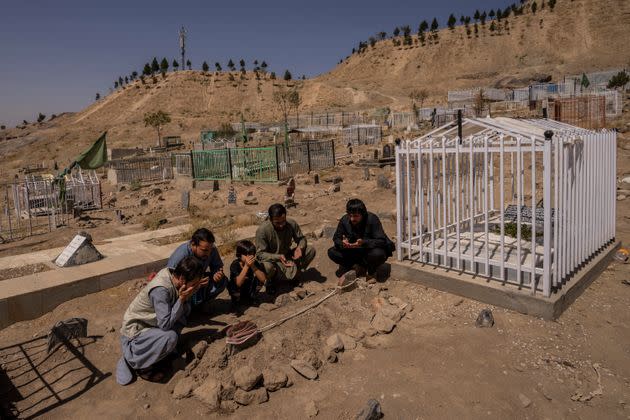 The Ahmadi family prays next to graves of family members killed by a U.S. drone strike in Kabul. (Photo: via Associated Press)