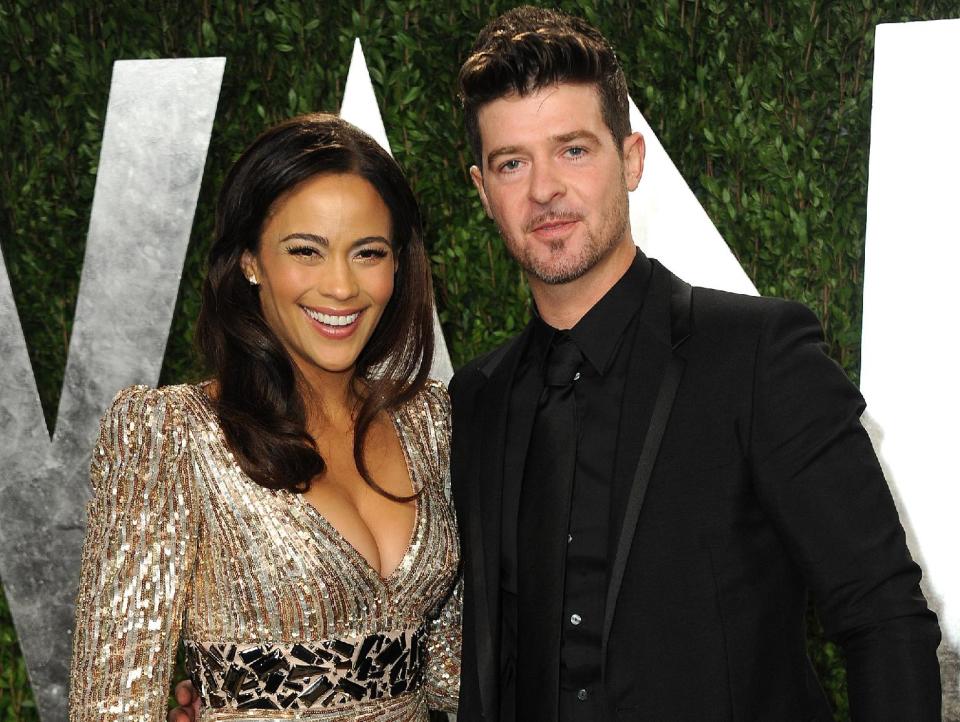 FILE - In this Feb. 24, 2013 file photo, Paula Patton and Robin Thicke arrive at the 2013 Vanity Fair Oscars Viewing and After Party at the Sunset Plaza Hotel in West Hollywood, Calif. Thicke originally didn't plan to release the unrated version of his music video for the song “Blurred Lines,” which features nude models prowling around him and rappers Pharrell and T.I. Thicke said his wife was OK with the models on the set and he sought her approval: “Obviously if she didn't like it I wouldn't put it out.” (Photo by Jordan Strauss/Invision/AP, File)