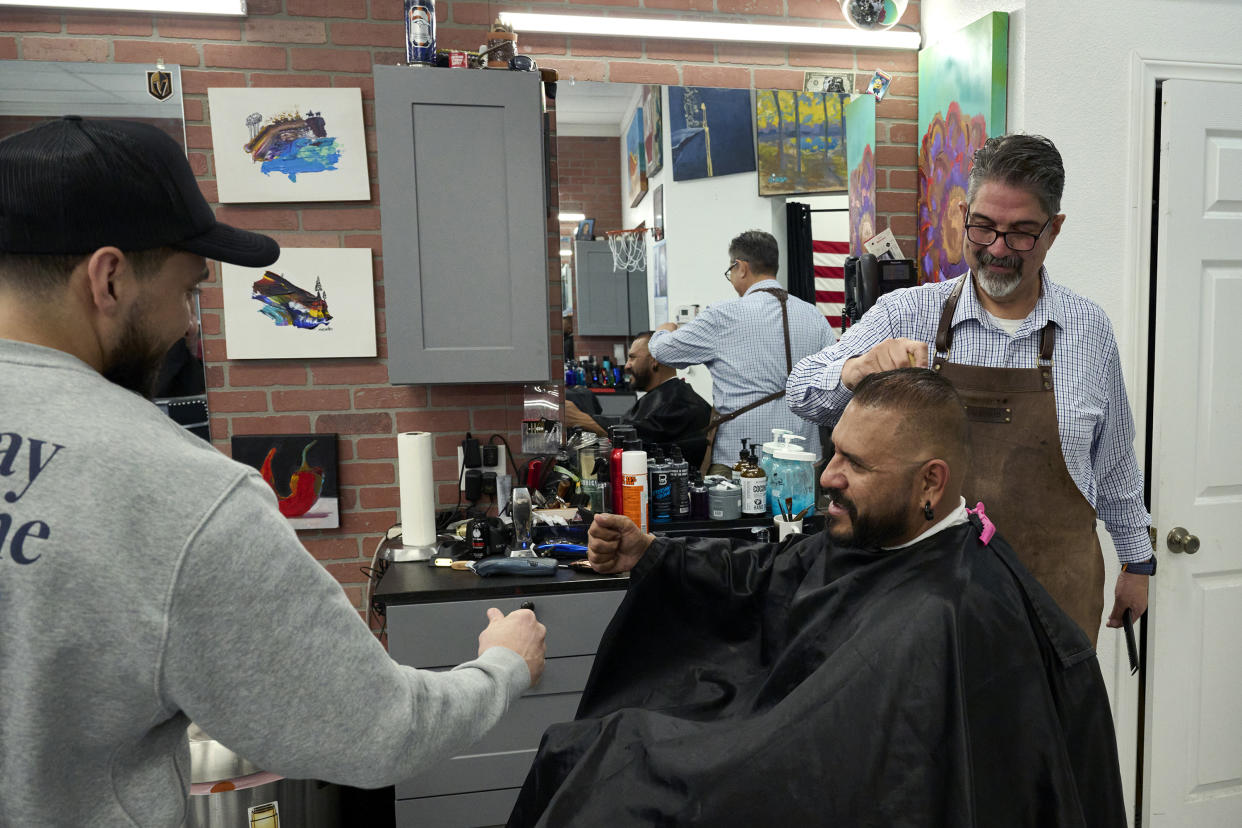 Los peluqueros Julio Vargas y Paul Madrid atienden al cliente Vince Saavedra en la peluquería Eastside Cutters de Las Vegas, el 5 de febrero de 2024. (Bridget Bennett/The New York Times)