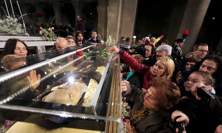 Faithful surround the exhumed body of the mystic saint Padre Pio in a glass, as arrives at the Catholic church of San Lorenzo fuori le Mura in Rome, February 3, 2016. REUTERS/Yara Nardi