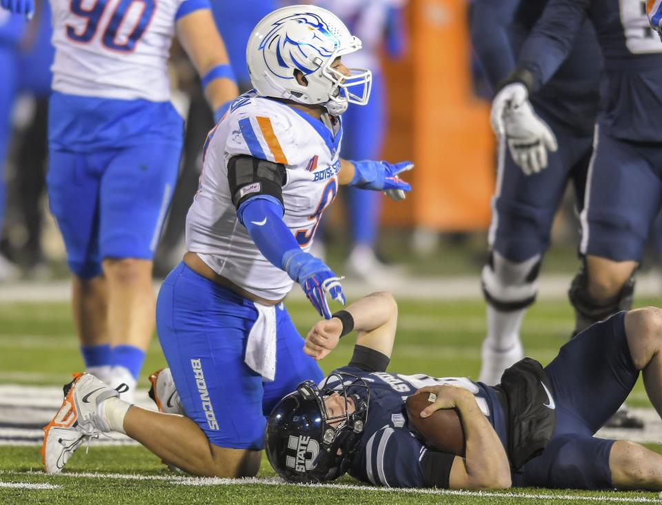 Boise State defensive end Ahmed Hassanein, left, celebrates after sacking Utah State quarterback McCae Hillstead, right, in the first half of an NCAA college football game Saturday, Nov. 18, 2023, in Logan, Utah. | Eli Lucero/The Herald Journal via AP