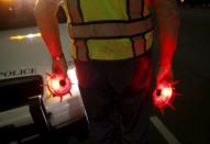 Retired Senior Volunteer Patrol member and traffic administrator Robert Stewart places illuminated safety markers on the road after responding to a stranded motorists during a night patrol in San Diego, California, United States February 10, 2015. (REUTERS/Mike Blake)