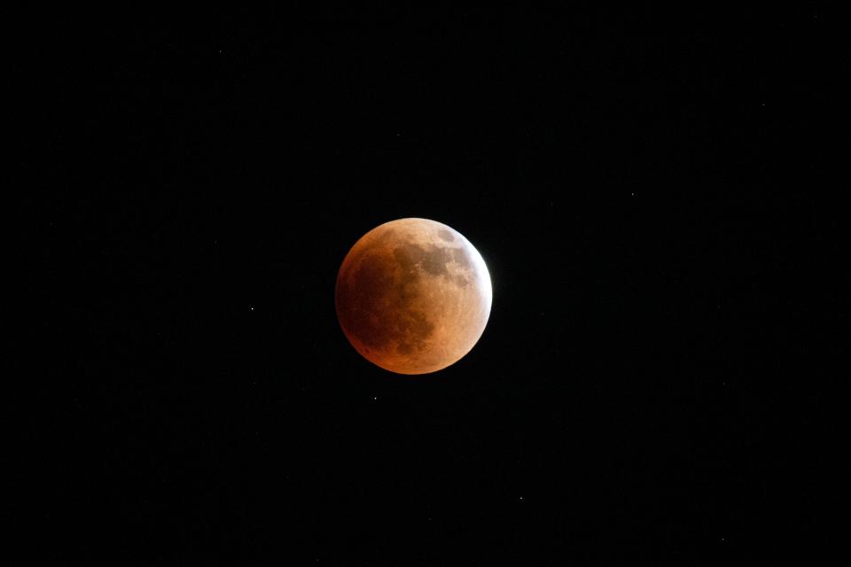 The moon glows red under earth's shadow during the Super Flower Blood Moon and lunar eclipse on May 15, 2022. 