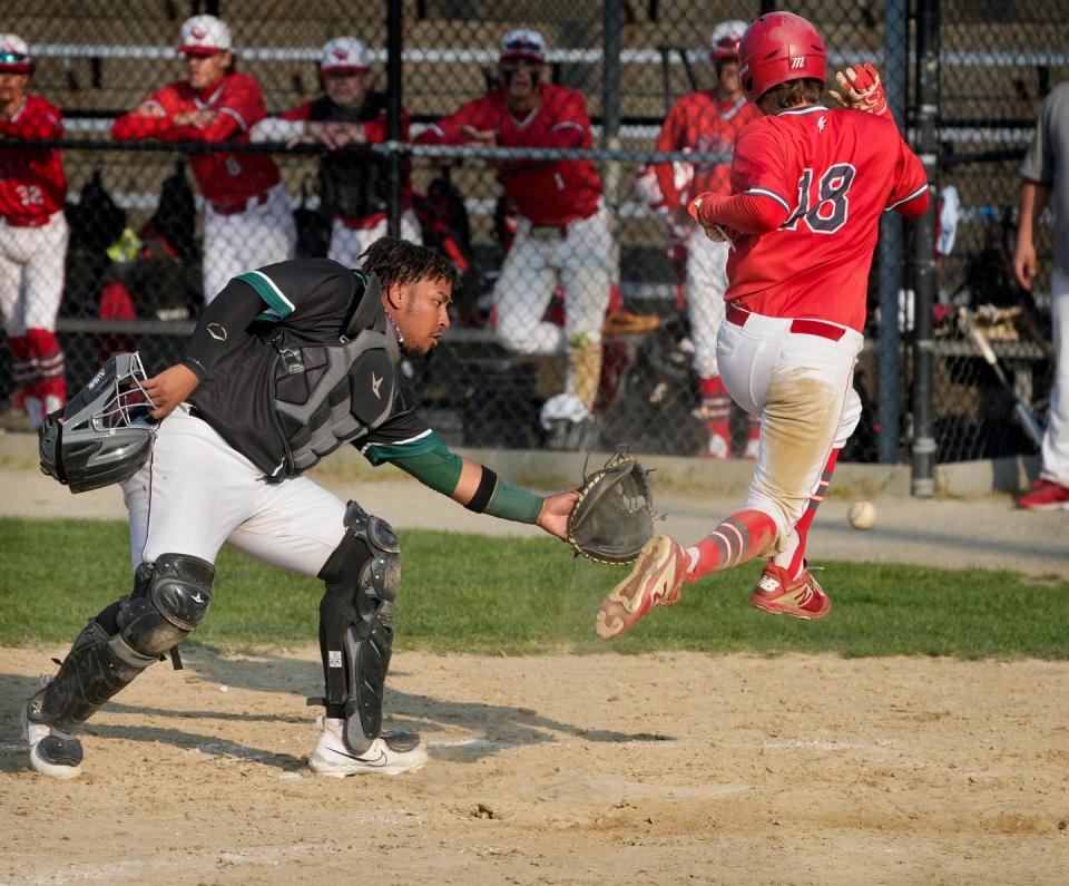 Falcon runner Chris Piscione leaps over the incoming throw to Cranston East catcher Carlos Merejo who was trying to make the tag in the 6th inning.  