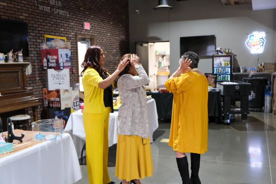 Yolanda Mendoza places a crown on an attendee at AM de Amarillo's Mujeres de Amarillo (women in yellow) event last weekend in east Amarillo.