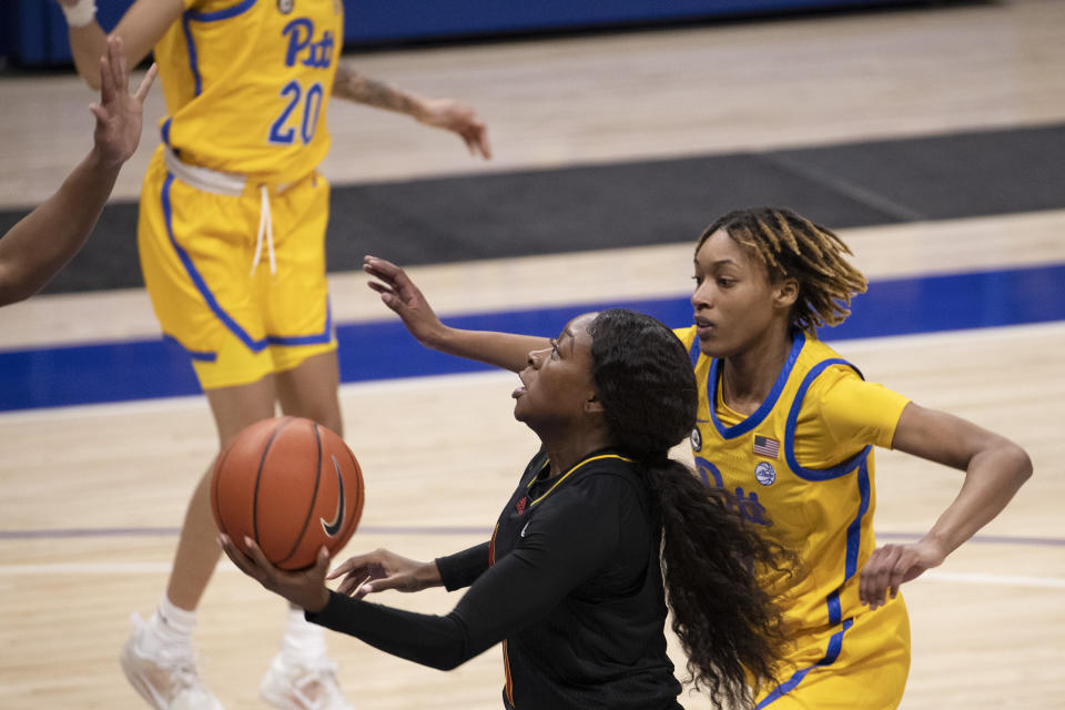 Louisville's Dana Evans (1) drives past Pittsburgh's Sandrine Clesca (0) to the hoop during an NCAA college basketball game, Thursday, Feb. 18, 2021, in Pittsburgh. (AP Photo/Rebecca Droke)