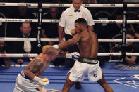 Oleksandr Usyk of Ukraine, left, throws a punch at Anthony Joshua of Britain during their WBA (Super), WBO and IBF boxing title bout at the Tottenham Hotspur Stadium in London, Saturday, Sept. 25, 2021. (AP Photo/Frank Augstein)