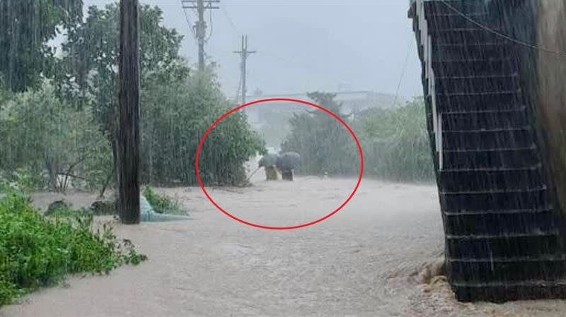 2人依偎走在滂沱大雨中，被鄰居不經意拍下。（圖／翻攝畫面）