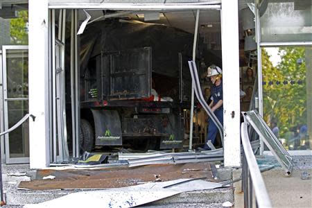 A Baltimore county firefighter officer walks out the broken door at the entrance of the WMAR-TV station in Towson, Maryland May 13, 2014. REUTERS/Jose Magana