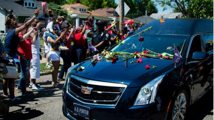 Mourners threw roses on Muhammad Ali's hearse on Friday as the funeral procession progressed in Louisville. (AP)
