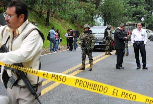 Forensic personnel inspect a US diplomatic vehicle on the Tres Marias-Huitzilac highway in Morelos, Mexico, August 24. Mexican federal police shot at the US diplomatic car as they chased criminals south of Mexico City, in a chaotic incident that left two US embassy employees wounded