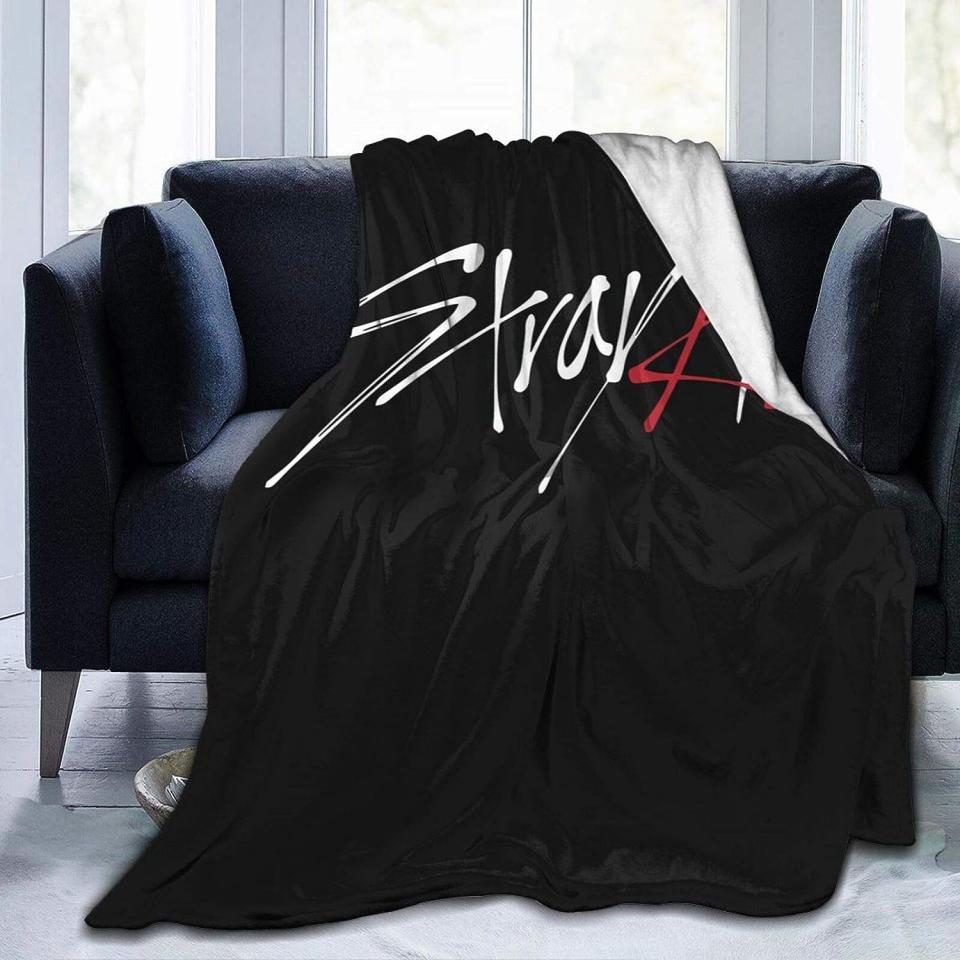 black blanket that says "Stray Kids" in white and red text