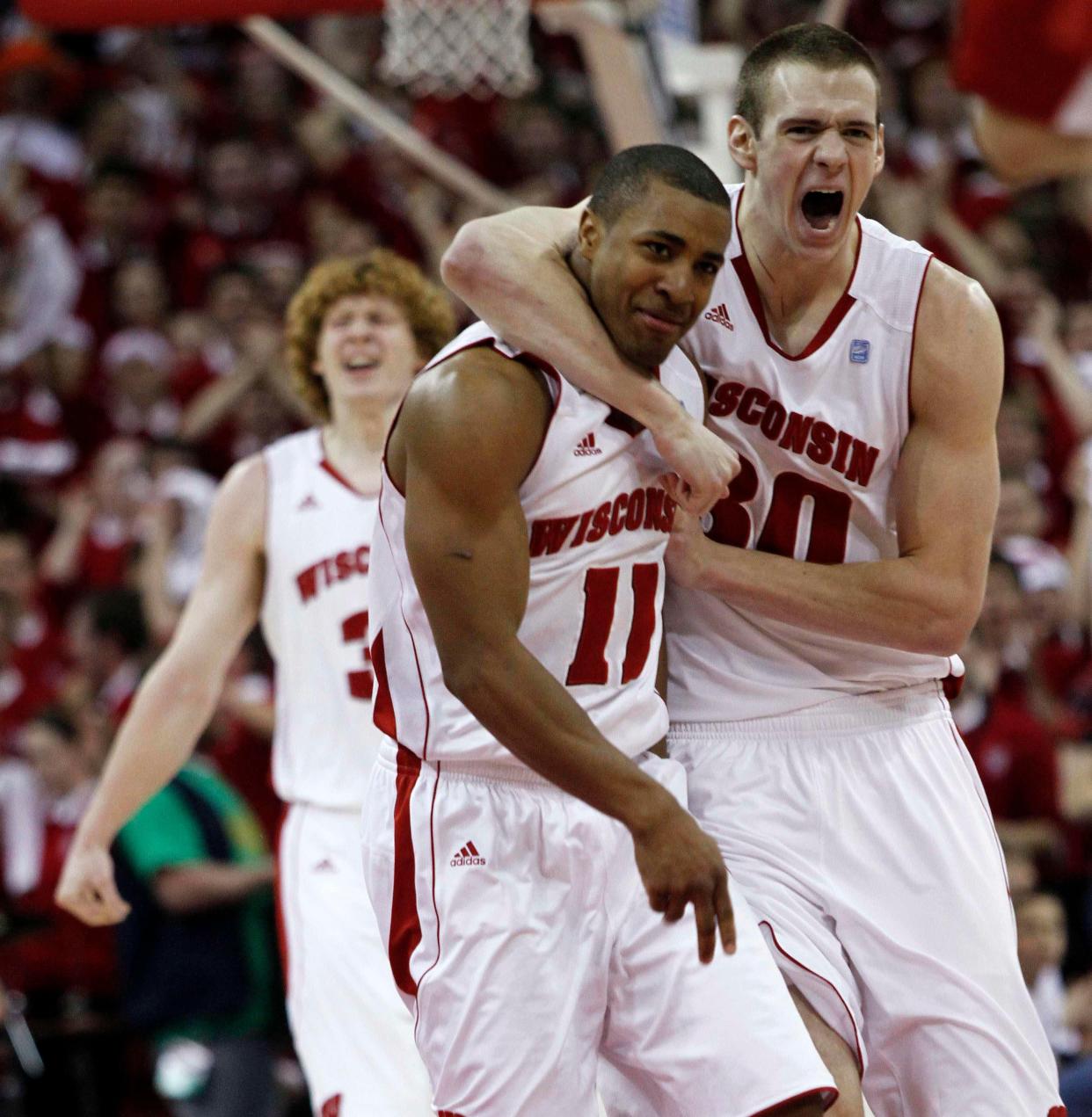 Wisconsin Badgers' Jordan Taylor (11) is hugged by teammate Jon Leuer (30) after making a basket against Ohio State Buckeyes late in the second half of their NCAA basketball game in Madison, Wisconsin February 12, 2011. Wisconsin went on to beat undefeated Ohio State 71-67.