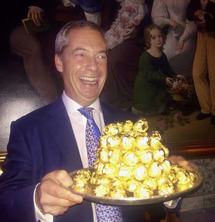 Nigel Farage, the interim leader of the United Kingdom Independence Party (UKIP) holds a platter of chocolates during a party at the Ritz hotel in London, Britain, November 23, 2016. REUTERS/Guy Faulconbridge