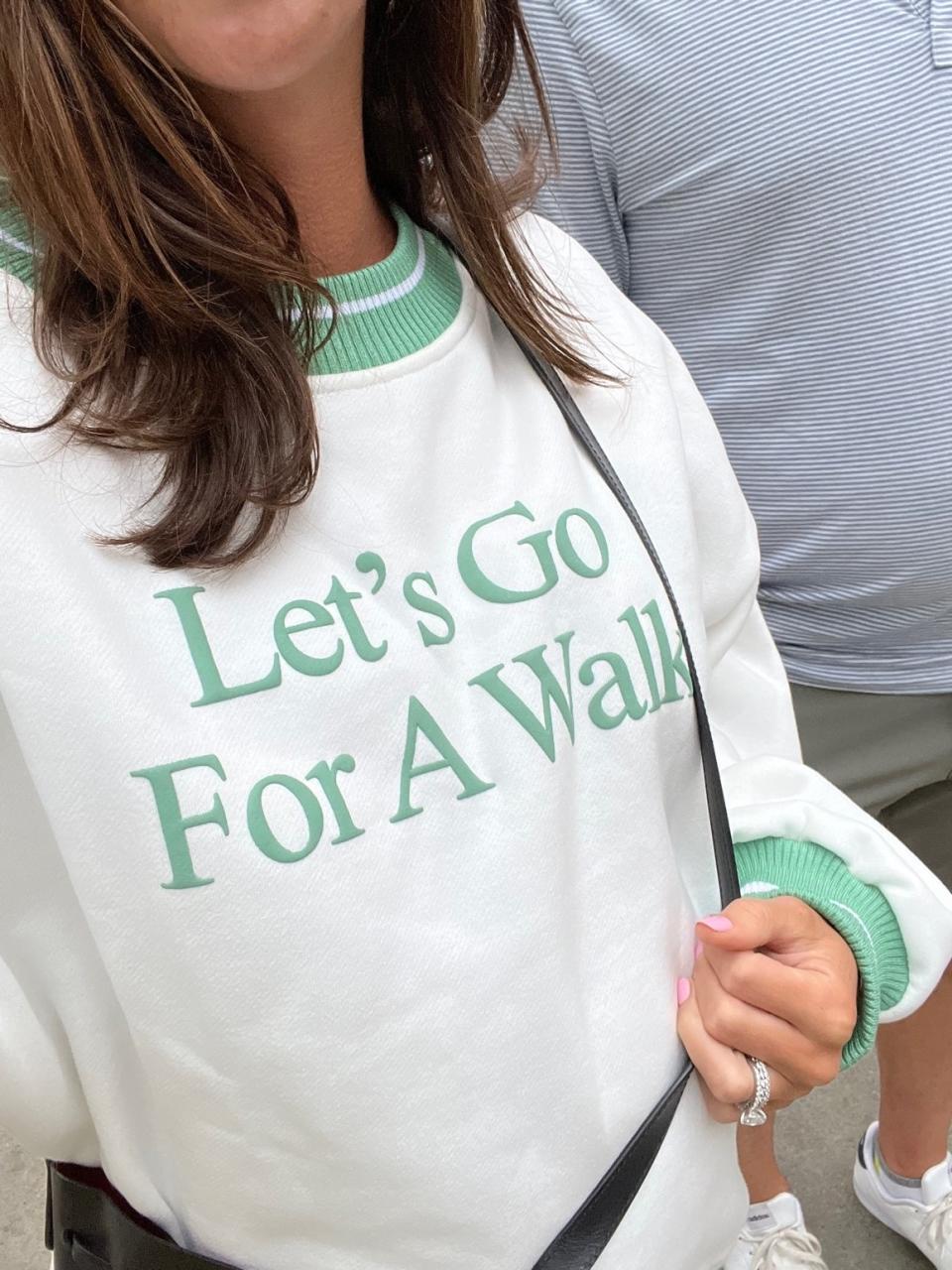 Me wearing a sweatshirt that says "let's go for a walk."