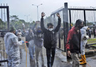 Soldiers in protective suits spray disinfectant on people entering the Gelora Bandung Lautan Api Stadium to receive the Sinovac COVID-19 vaccine during a mass vaccination in Bandung, West Java, Indonesia, Thursday, June 17, 2021. Indonesia's president ordered authorities to speed up the country's vaccination campaign as the World Health Organization warned Thursday of the need to increase social restrictions in the country amid a fresh surge of coronavirus infections caused by worrisome variants. (AP Photo/Bukbis Candra)