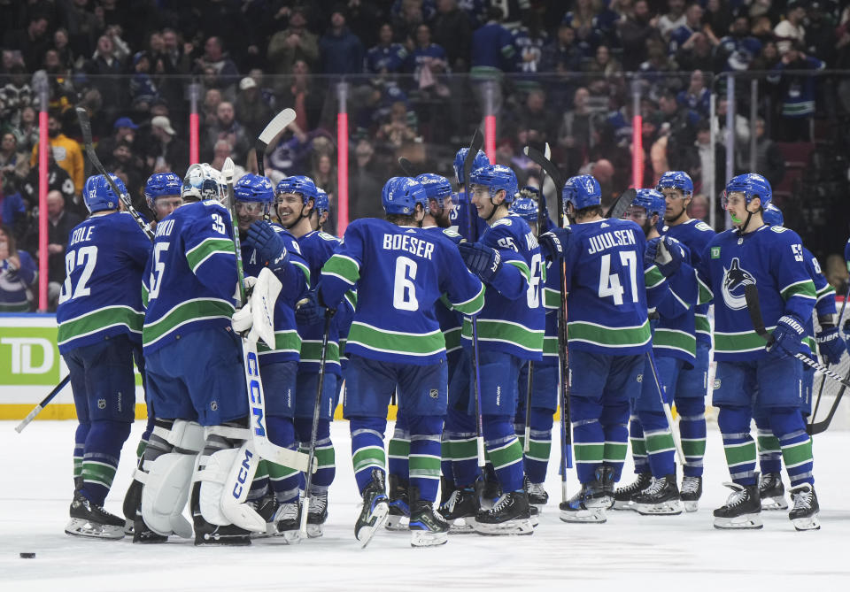 Vancouver Canucks celebrate after defeating the New York Islanders in overtime in an NHL hockey game Wednesday, Nov. 15, 2023, in Vancouver, British Columbia. (Darryl Dyck/The Canadian Press via AP)