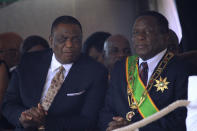 FILE - In this Monday, Aug. 13, 2018, file photo, Zimbabwe's President Emmerson Mnangagwa, right, sits with his Deputy Constantino Chiwenga, left, during a Heroes' Day event in Harare, Zimbabwe. The coronavirus pandemic could narrow one gaping inequality in Africa, where some heads of state and other elite jet off to Europe or Asia for health care unavailable in their nations but as global travel restrictions tighten, they might have to take their chances at home. (AP Photo/Tsvangirayi Mukwazhi, File)
