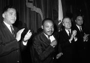 <p>Dr. Martin Luther King Jr., as he sits down following his speech to the joint session of the Massachusetts Legislature in Boston, April 22, 1965. Applauding at left is Massachusetts Attorney Gen. Edward W. Brooke. King will lead a civil rights march to Boston Common. (AP Photo) </p>