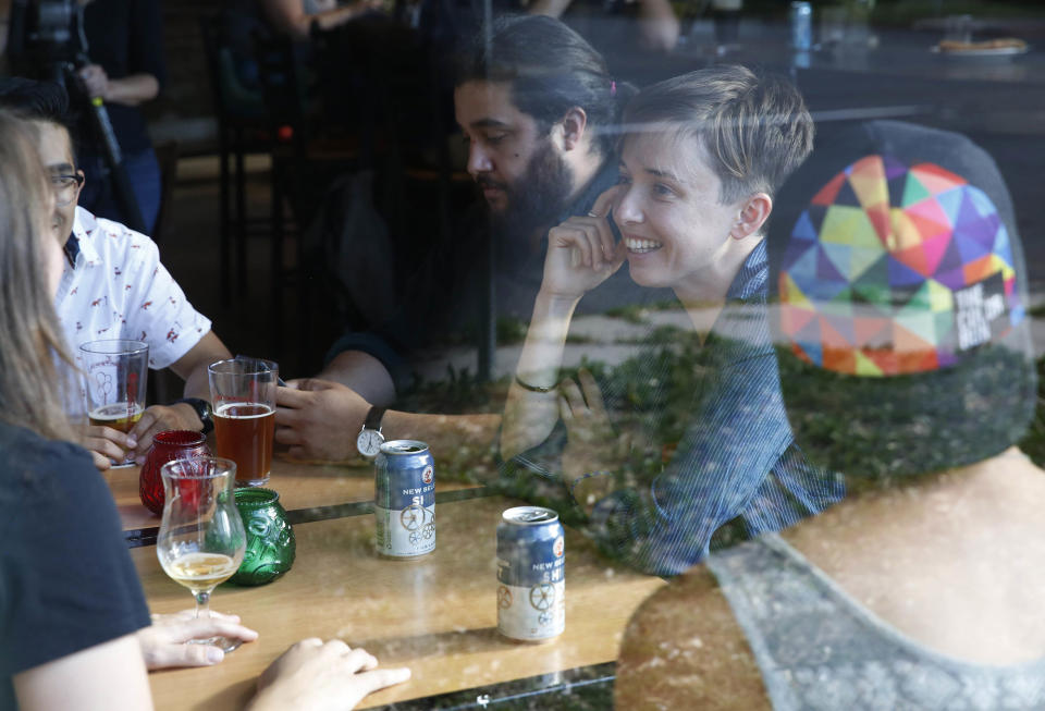 <p>Diana Downard, 26, a Bernie Sanders supporter who now says she will vote for Hillary Clinton, has drinks with friends at a pub in Denver on July 6, 2016. “Millennials have been described as apathetic, but they’re absolutely not,” says Downard “Millennials have a very nuanced understanding of the political world.” (AP Photo/Brennan Linsley) </p>