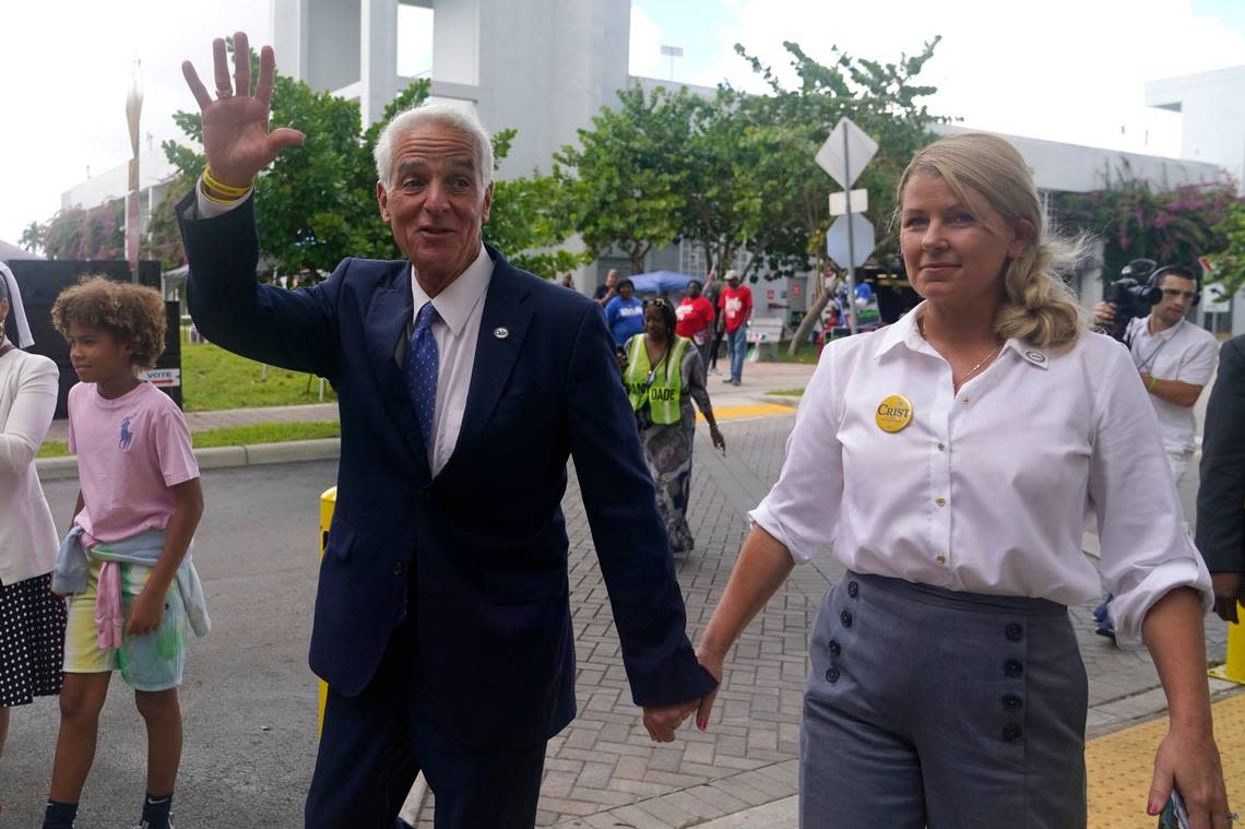 Democratic candidate for Florida governor Charlie Crist, left, waves as he arrives with his fiancee Chelsea Grimes, right, as he campaigns at an early voting location, Sunday, Nov. 6, 2022, in Miami.