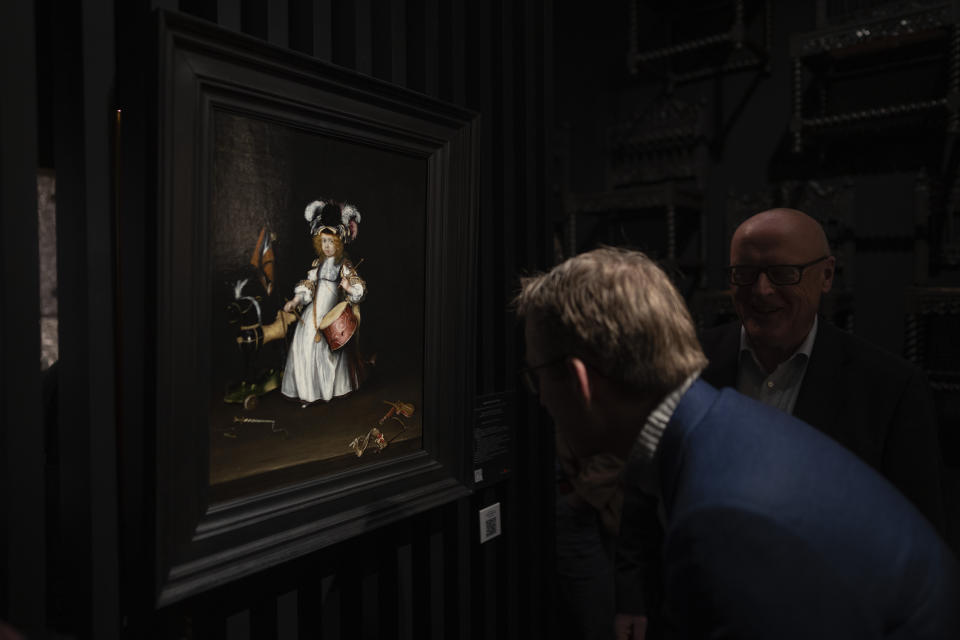 Pieter Roelofs, head of Fine Arts of The Rijksmuseum, center, and his predecessor Gregor Weber, right, look at the museum's latest acquisition, a Portrait of Moses ter Borch as a Two Year Old by female painter Gesina ter Borch (1631-1690), at the European Fine Art Foundation, known by its acronym TEFAF, in Maastricht, southern Netherlands, Thursday, March 7, 2024. (AP Photo/Peter Dejong)