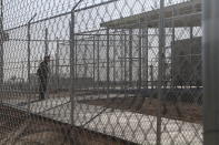 A Border Patrol agent wait to show reporters an immigration holding facility, Tuesday, Feb. 25, 2020, in El Paso, Texas. The complex of modular buildings can house and process 1,040 and will replace tents hastily erected for processing last spring. U.S. Customs and Border Protection