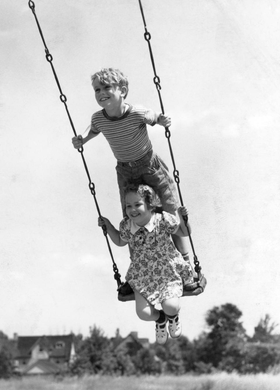 Circa 1930s:  Boy And Girl On Swing.  (Photo by H. Armstrong Roberts/Retrofile/Getty Images)