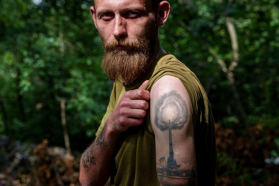 A Ukrainian soldier, Anton, 32, of 43rd artillery brigade, shows off his tattoo showing a self-propelled howitzer (AP)