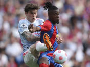 Manchester United's Victor Lindelof, left, tries to tackle Crystal Palace's Wilfried Zaha during the English Premier League soccer match between Manchester United and Crystal Palace at Selhurst Park stadium in London, Sunday, May 22, 2022. (AP Photo/Ian Walton)