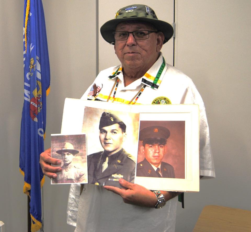 Dan King, an Oneida Nation member and Vietnam War veteran, holds photos of his grandfather during World War I, his father during World War II and himself during his service.