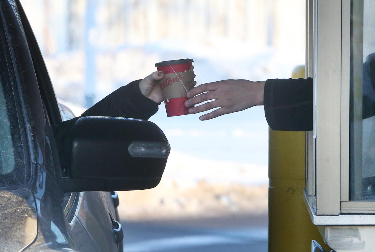 TORONTO, ON- JANUARY 10  -  A tea is passed to a customer at the thrive thru. Fight for 15 and Fairness holds a rally outside  the Tim Hortons location on Lawerence Avenue East in Scarborough in Toronto. Rallies are being held in other Ontario cities Wednesday where franchisees have scrapped paid breaks and  fully covered health and dental plans in response to the increase in minimum wage in Ontario.  in Toronto. January 10, 2018.  Tim Horton's corporate parent is Restaurant Brands International.        (Steve Russell/Toronto Star via Getty Images)