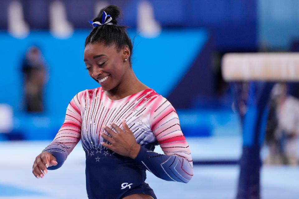 Simone Biles reacts after competing on the women's balance beam.