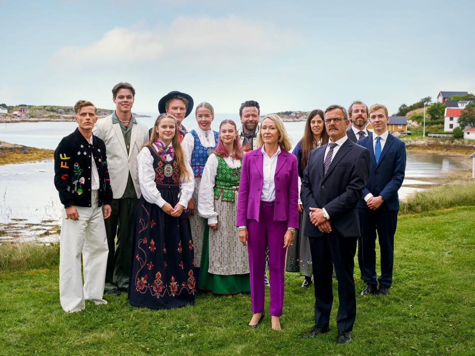 a group of people, the left dressed in traditional norwegian clothes, the right dressed in suits