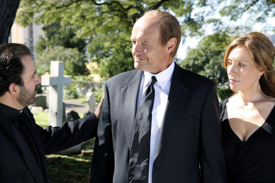 A priest speaking to a couple wearing black at a cemetery; still from 'Lost'