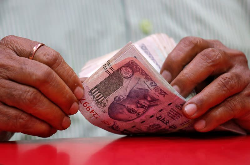 FILE PHOTO: A man counts Indian currency notes inside a shop in Mumbai