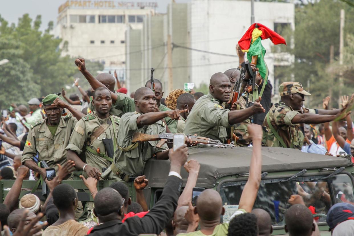 Crowds cheer as soldiers parade in vehicles along the Boulevard de l'Independance in Mali on Tuesday: Getty Images