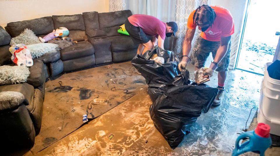 Kyle Mayberry and JD Dixon help pick up flood damaged items in an East St. Louis home. The volunteers with Empire 13 and We Are The People STL removed furniture, carpet, and other items from East St. Louis homes that were flooded. Derik Holtmann/dholtmann@bnd.com