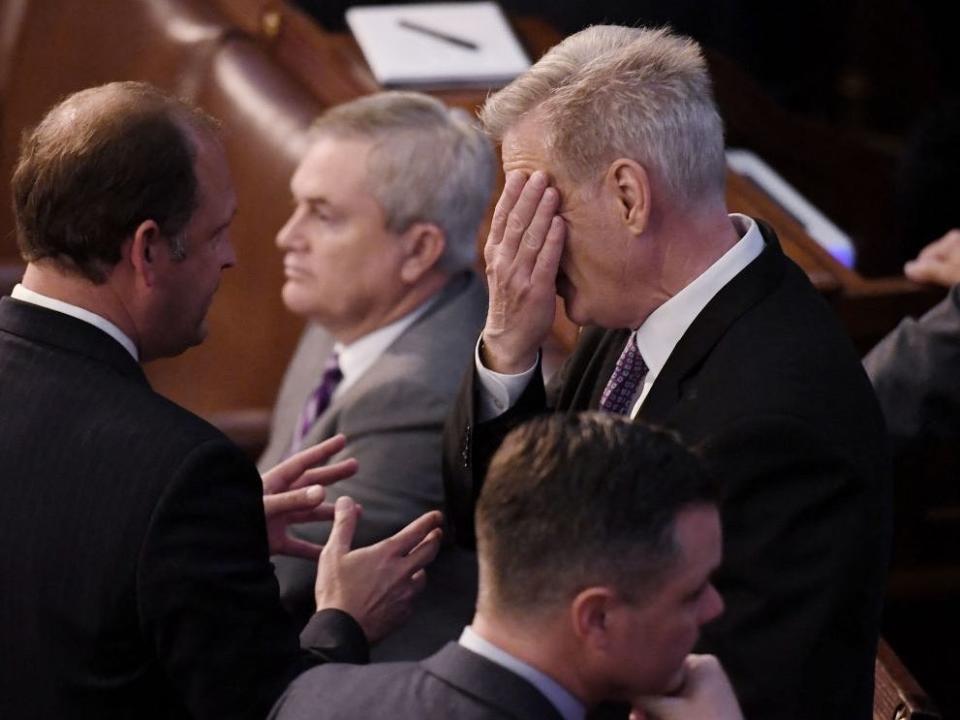 Kevin McCarthy puts his face in his hands on the House floor