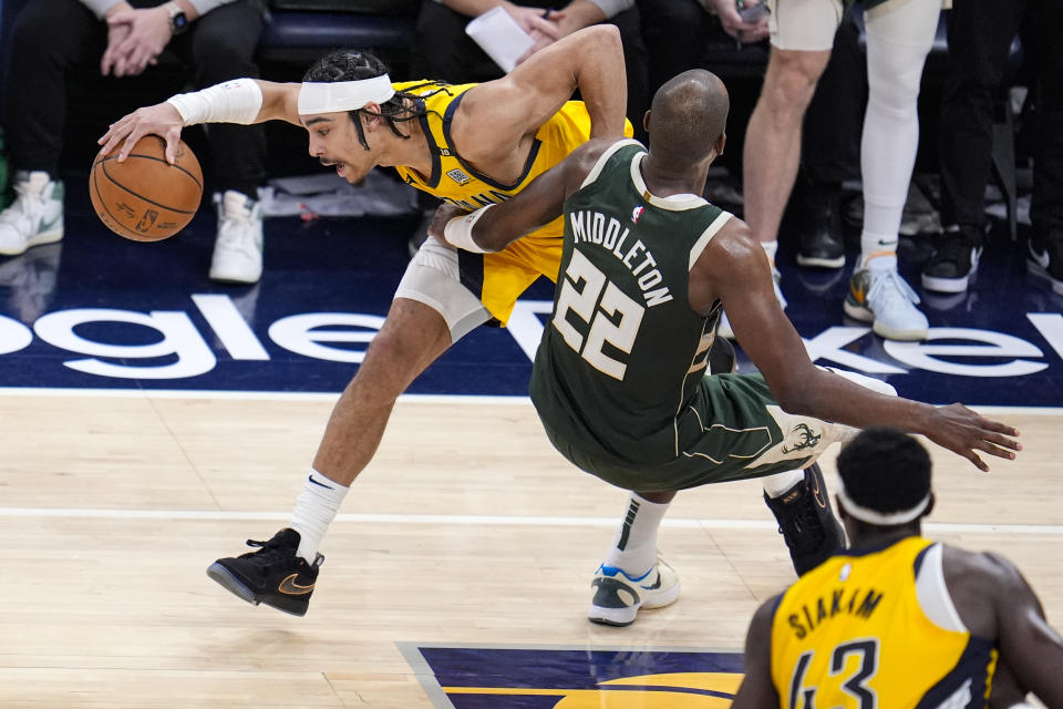 Indiana Pacers guard Andrew Nembhard (2) is fouled by Milwaukee Bucks forward Khris Middleton (22) during the second half in Game 2 in an NBA basketball first-round playoff series, Friday, April 26, 2024, in Indianapolis. (AP Photo/Michael Conroy)