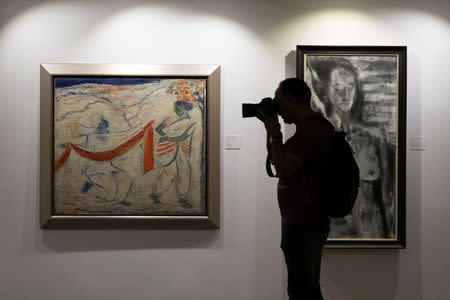 A journalist takes photos of artworks once part of billionaire jeweller Nirav Modi's collection ahead of their auction at a gallery in Mumbai, India, March 25, 2019. REUTERS/Danish Siddiqui