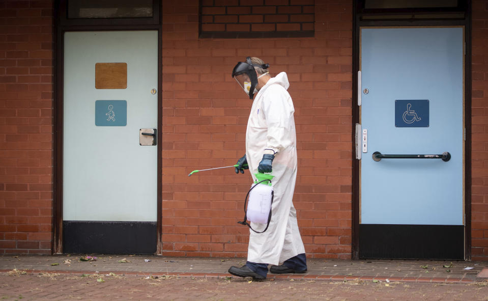 A worker for Leicester City Council disinfects public toilets in Leicester, England, Monday June 29, 2020. The central England city of Leicester is waiting to find out if lockdown restrictions will be extended as a result of a spike in coronavirus infections. (Joe Giddens/PA via AP)