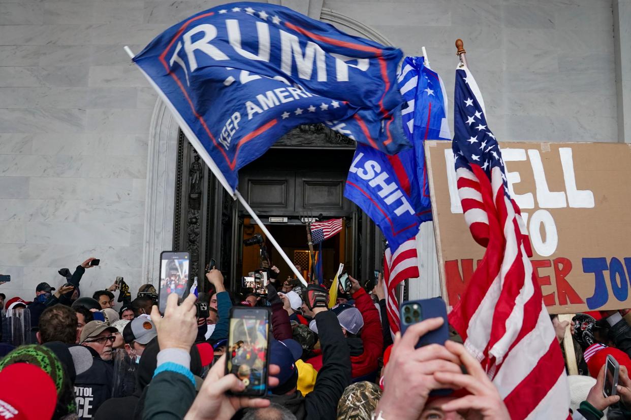 <p>Crowds pictured breaking into the US Capitol on January 6. A new report claims that online vigilante groups are searching for remaining suspects</p> (AP)