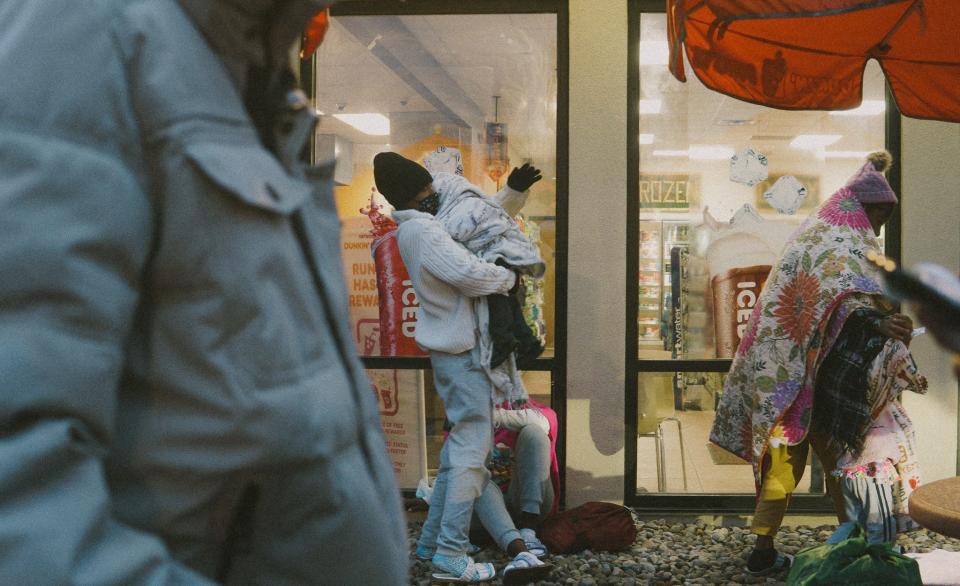 At 5 a.m., the children tried to get to sleep on pebbled rocks under Mountain Mart’s awning. It was in the low 40s and drizzling in Plattsburgh, a remote New York town a few miles from the Canadian border. They wore only pajamas and sandals with socks, huddling together under quilted blankets. A 9-month-old baby was tucked underneath. Yermain Piñango, 37, stood at the curb looking for a taxi driver.